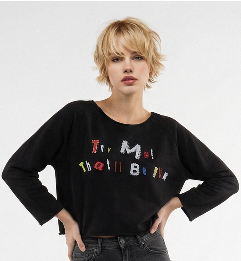 Person wearing a black sweater with colorful text on a white background