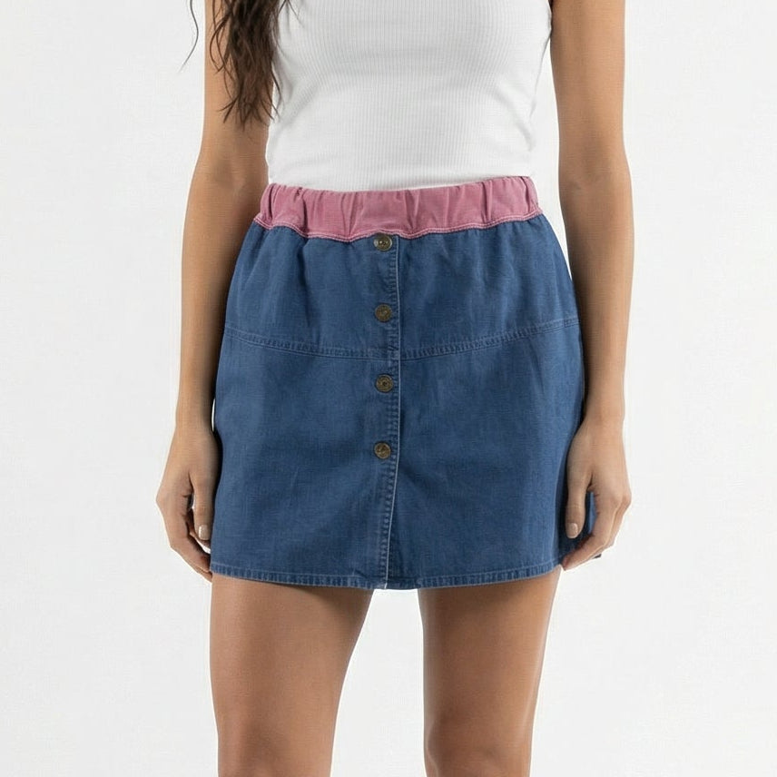 Woman wearing a white tank top and blue denim skirt on a white background