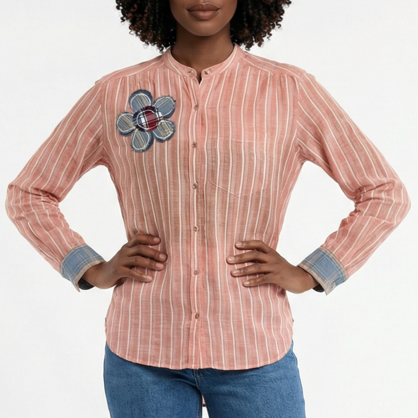 Woman wearing a striped shirt with a floral patch on a white background