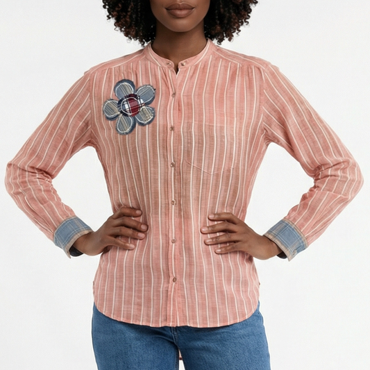 Woman wearing a striped shirt with a floral patch on a white background